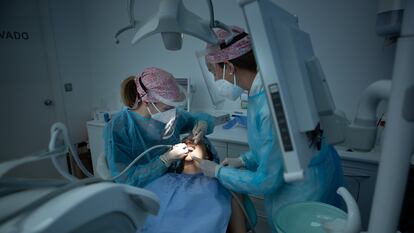 Dentistas atienden a un paciente en una clínica de Madrid.