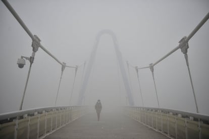 En Tianjin, el nivel de partículas ha alcanzado los 334 microgramos por metro cúbico según la agencia de protección ambiental local. En la imagen, una mujer camina entre la niebla tóxica en Tianjin (China).