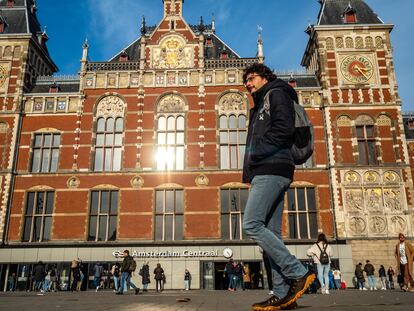 A man walks in front of Amsterdam central station.
