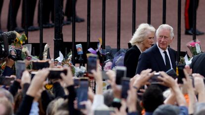 King Charles and Queen Camilla are cheered by the crowd as they walk outside Buckingham Palace on Friday.