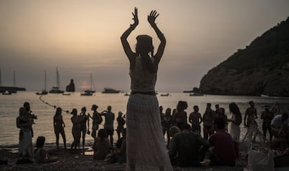 Una mujer baila al atardecer en la cala Benirrás de Ibiza.