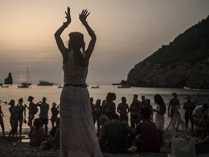 Una mujer baila al atardecer en la cala Benirrás de Ibiza.