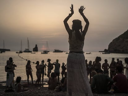 Una mujer baila al atardecer en la cala Benirrás de Ibiza.