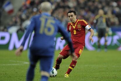 Xavi pasa el balón ante el francés Jallet.