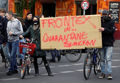 Protesta en Berlín en mayo de 2020 en la que dos manifestantes llevan una pancarta que dice: "Poned a Frontex en cuarentena".