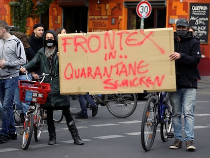 Protesta en Berlín en mayo de 2020 en la que dos manifestantes llevan una pancarta que dice: "Poned a Frontex en cuarentena".