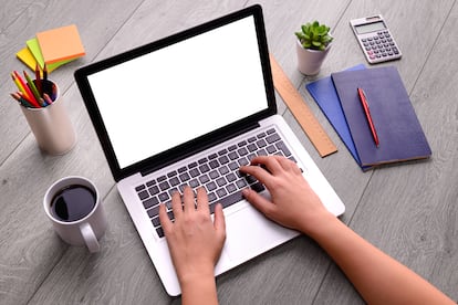 Woman hand using blank screen laptop computer on an office desk.