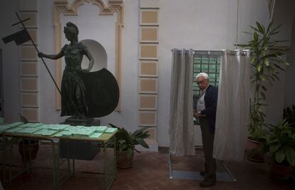 Un votante sale de la cabina, en un colegio electoral de Carmona, Sevilla.