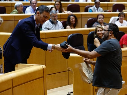 El senador de Mès Per Mallorca Vicenç Vidal, le entrega una camiseta a Pedro Sánchez durante el debate en la Cámara Alta.