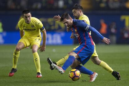 Leo Messi intenta llevarse el balón ante los jugadores del Villarreal, Jaume Costa y Bruno Soriano, durante el encuentro.