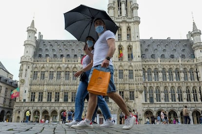 Una pareja pasea por el centro de Bruselas. Las nuevas medidas para el uso obligatorio de mascarillas en mercados, edificios públicos y avenidas principales de Bélgica han entrado finalmente en vigor este sábado tras constatar un aumento de las cifras de contagios por coronavirus, para prevenir la posibilidad de una segunda ola.