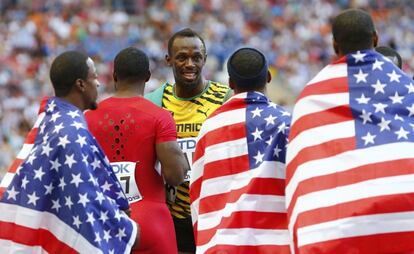Bolt es felicitado por los componentes del equipo de estados unidos después de que Jamaica gane el 4x100m.