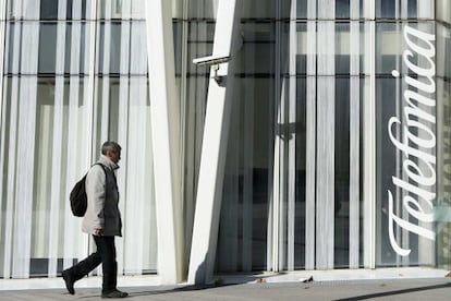 Un hombre pasa junto a la sede de Telef&oacute;nica, en Barcelona.