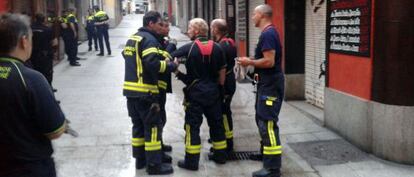 Un grupo de bomberos frente al inmueble del incendio.