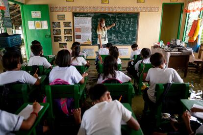 Millones de niños regresaron este lunes a las clases presenciales en Filipinas, que reabrió sus colegios públicos y privados tras más de dos años de educación a distancia debido a la pandemia de la covid-19. En la foto, una maestra da clase en una escuela inundada debido a la marea alta, en Macabebe (Filipinas), este lunes.