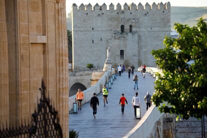 Varias personas se ejercitan a primera hora de la mañana por el puente romano de Córdoba. 