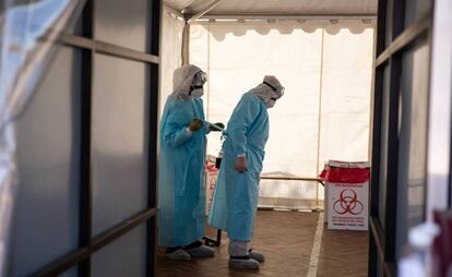 Dos sanitarios se quitan los trajes de protección, que serán desechados en un cubo de basura específico. Todo lo que se desecha en las instalaciones, ya sean mascarillas, delantales, comida o hasta los periódicos retirados de las salas de espera, se considera residuos médicos y se tira a un contenedor específico.