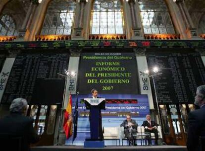 Zapatero explica su informe económico en la sala principal de la Bolsa de Madrid. Detrás, Pedro Solbes y David Taguas.