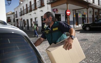 Un guardia civil con una caja de evidencias tras registrar el Ayuntamiento de Valdemoro. 