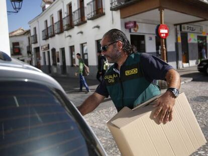 Un guardia civil con una caja de evidencias tras registrar el Ayuntamiento de Valdemoro. 