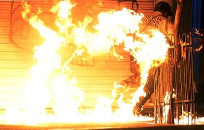 Un polic&iacute;a es golpeado por un c&oacute;ctel molotov.