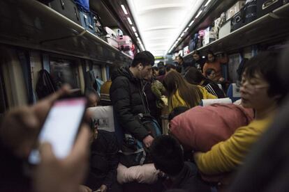 Pasajeros buscan sitio y se acomodan en uno de los vagones del tren que viaja desde Pekín hasta Chengdu.