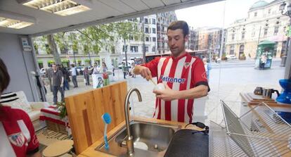 El actor que interpreta a Jon comienza la jornada fregando los cacharros, a la vista de los transeúntes de Bilbao.