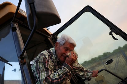 Paco Amposta, de 90 años, se emociona mientras usa una excavadora para limpiar el campo alrededor de su casa cerca del incendio forestal, en Xerta, este martes.