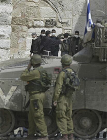 Los ocho palestinos y los dos monjes salen de la Basílica de Belén bajo la mirada de los soldados israelíes.