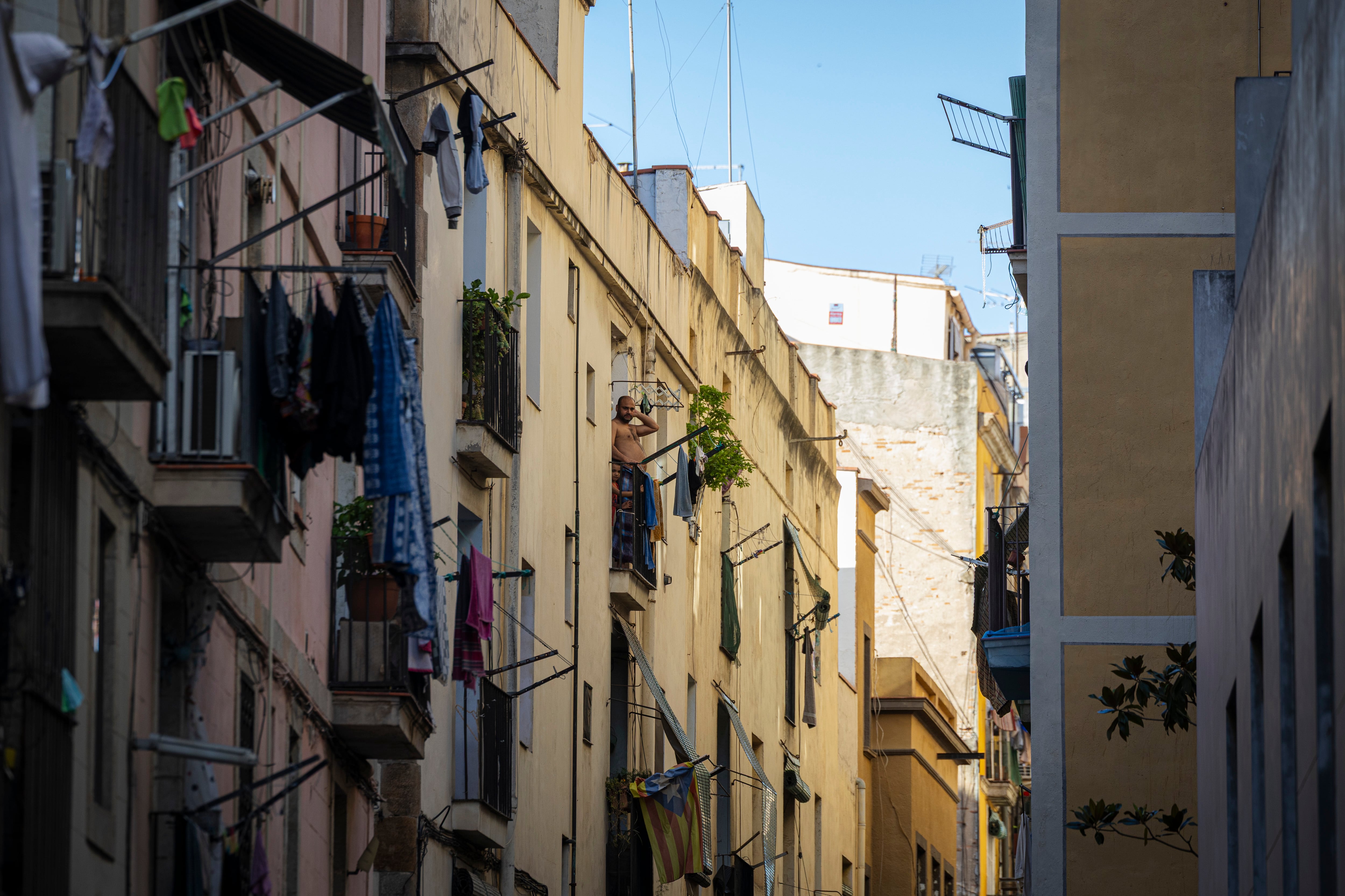 Un hombre con un niño en un balcón de la Calle de la Cera, en el Raval.