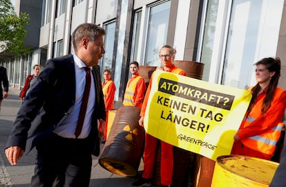 El ministro de Economía y Clima, Robert Habeck, pasa frente a un cartel que pide no prolongar "ni un día más" la energía nuclear en Alemania de camino a la rueda de prensa que ha ofrecido este lunes en Berlín.