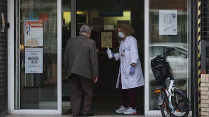 Una sanitaria recibe a un paciente a la entrada del centro de Salud Estrecho de Corea, en Madrid