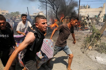 Varias personas trasladan a un herido tras un bombardeo israelí sobre Al Mawasi, este sábado. 