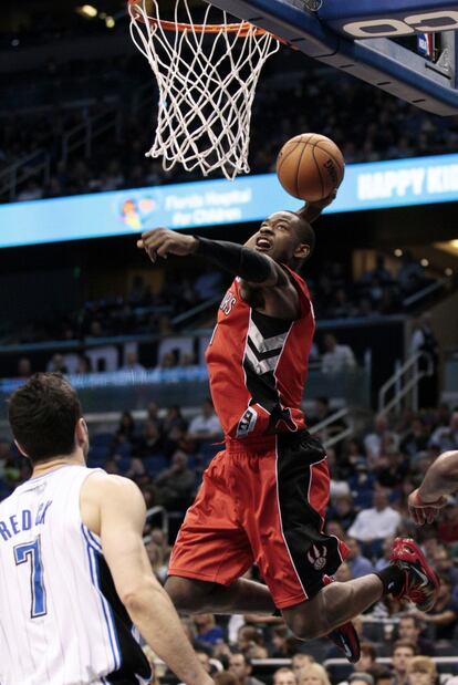 Terrence Ross, de Toronto, se dispone a hacer un mate ante Redick, de los Magic.