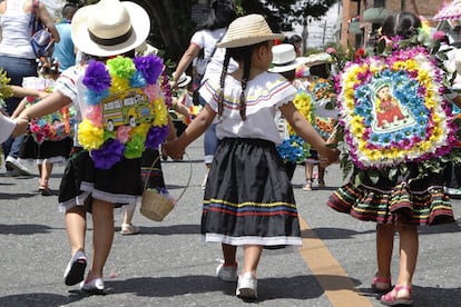 Unos 2.500 niños desfilan por las calles de Medellín con sus arreglos de flores a la espalda.