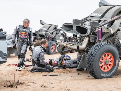 Carlos Sainz asiste a su compañero de equipo en Audi, Mattias Ekström, en la séptima etapa del Dakar.