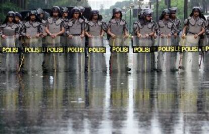 Un grupo de policías indonesios monta guardia en el centro de Yakarta, tras una tormenta, para vigilar las manifestaciones en apoyo del presidente Wahid.