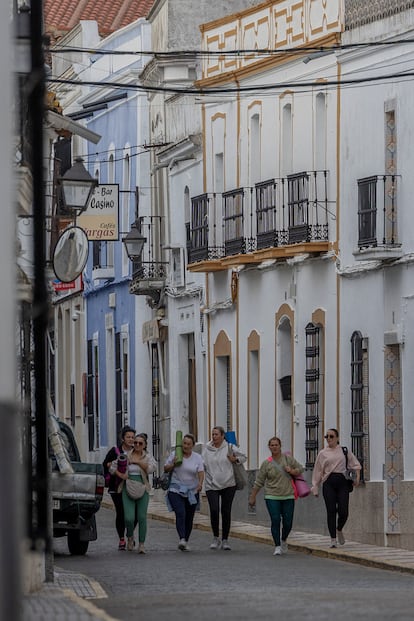 Varias mujeres se dirigen a la clase de pilates en el pabellón municipal de Higuera de Vargas, Badajoz. 