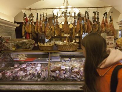 Clientes en una charcuter&iacute;a en la tienda GUM de Moscu con jamones ib&eacute;ricos en el expositor.
 
  