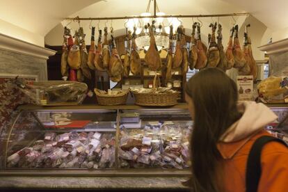 Clientes en una charcutería en la tienda GUM de Moscu con jamones ibéricos en el expositor.