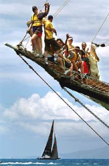 Un grupo de espectadores observa desde un barco el paso del velero <i>OneWorld.</i>