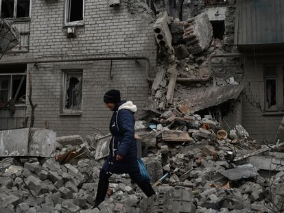A woman walks past debris of the destroyed house after recent Russian air strike in Chasiv Yar, Ukraine, Sunday, Nov. 27, 2022. Shelling by Russian forces struck several areas in eastern and southern Ukraine overnight as utility crews continued a scramble to restore power, water and heating following widespread strikes in recent weeks, officials said Sunday. (AP Photo/Andriy Andriyenko)