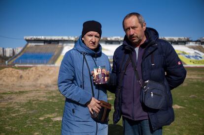 Svitlana y Oleksiy Yeremenko, con una foto de su fallecido hijo Pavlo, en el estadio de fútbol de Chernihiv.