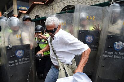 Un opositor frente a la policía antidisturbios durante una protesta en Caracas. 