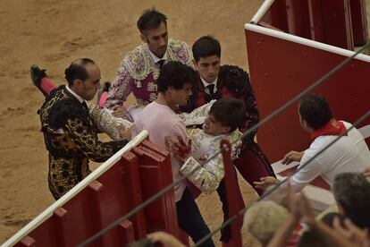 El torero Gonzalo Caballero es trasladado a la enfermer&iacute;a por su cuadrilla y el torero Miguel Abell&aacute;n, hoy en Pamplona.