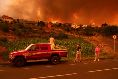 Varias personas tratan de alcanzar sus casas en Benijos mientras el fuego avanza en La Orotava (Tenerife). 