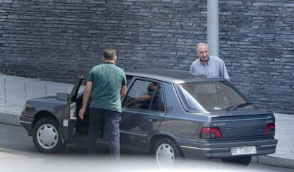 El exjefe de la Policía de Ourense, Abelardo Ulloa (de frente) junto al coche con el agente que usa de chófer particular.