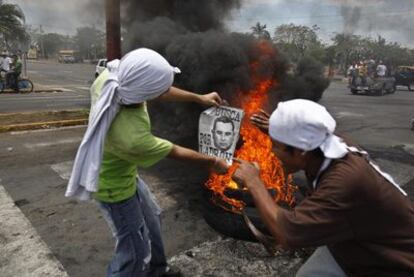 Dos jóvenes sandinistas muestran en Managua un cartel contra el anterior presidente Arnoldo Alemán.