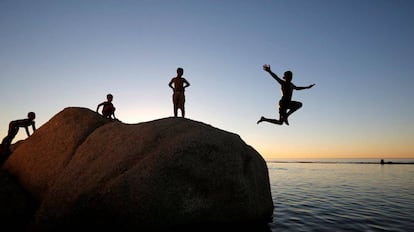 Varios niños saltan en una piscina, en Camps Bay (Sudáfrica).