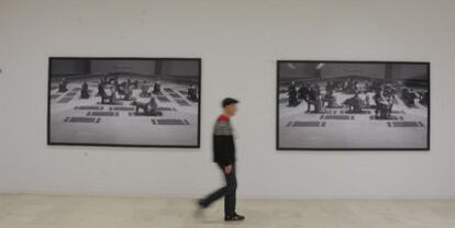 Siempre reticente a ser retratado, Santiago Sierra pasea ante dos imágenes, en enero de 2009, de su vídeo <i>Los penetrados,</i> en la galería Helga de Alvear de Madrid.
